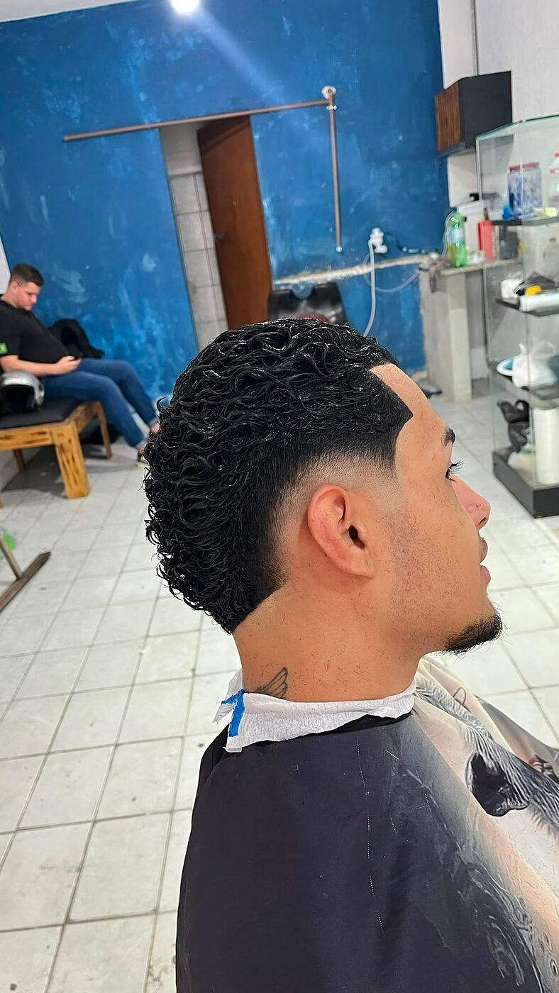 Cabelo cacheado com degradê baixo e barba feita