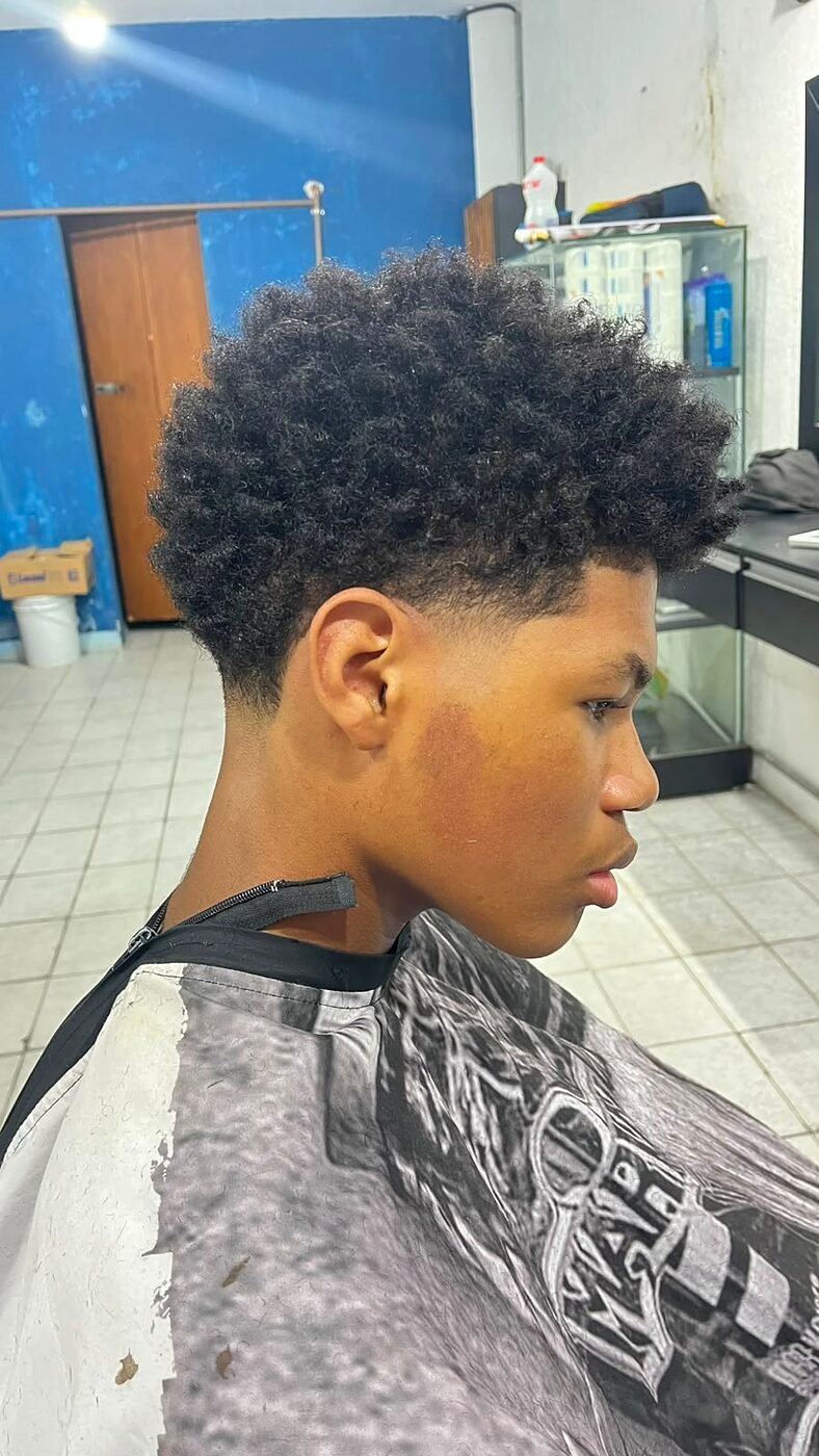 Corte em cabelo cacheado com degradê e luzes